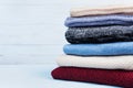 Heap of wool sweaters and knitted winter clothes on blue wooden background. Copy space for text. Royalty Free Stock Photo