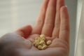 Heap of yellow medical pills in young female hand. Vitamins in human palm Royalty Free Stock Photo