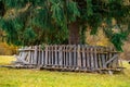 The heaped fence lies on a green meadow near a large tree