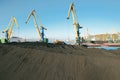 Heaps of coal in the Murmansk commercial seaport for further transportation by sea dry cargo vessels Royalty Free Stock Photo