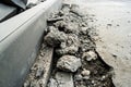 Heaps of demolished asphalt lying on the sidewalk near the pit for installing a curb. Broken asphalt. A hole in the road surface.