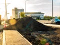 heaps of earth for arranging a lawn or a green strip are piled along the carriageway and partly on the sidewalk Royalty Free Stock Photo