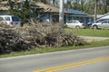 Heaps of limbs and branches debris from hurricane winds on street side waiting for recovery truck pickup in residential Royalty Free Stock Photo