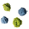 Heaps of matcha green and blue tea powder isolated on white background