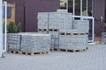 heaps of new white bricks and gray paving slabs on a pallet outdoors in a warehouse