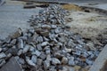 Heaps of paving stones lie on the road, laying stones, unfinished work. road pedestrian area