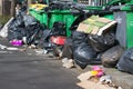 heaps of rubbish bags and garbage containers over bicycle lanes Royalty Free Stock Photo