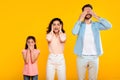 Hear no evil, see no evil, speak no evil. Family of three people covering eyes, ears and mouth, yellow background Royalty Free Stock Photo