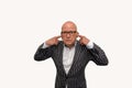 Bald adult man with glasses in a striped jacket makes the gesture to hear nothing