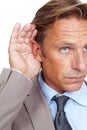 Hear, secret and businessman holding his ear in a studio while listening to a whisper conversation. Communication Royalty Free Stock Photo
