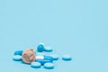Hearing aid and blue pills on blue background. Medical, pharmacy and healthcare concept. Copy space. Empty place for text or logo