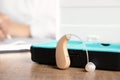 Hearing aid with box on wooden table Royalty Free Stock Photo