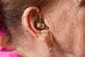 Hearing aid device in senior woman ear - closeup detail Royalty Free Stock Photo