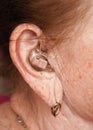 Hearing aid device in senior woman ear - closeup photo Royalty Free Stock Photo