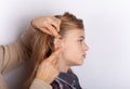 Hearing aid inserting in a young girl ear Royalty Free Stock Photo