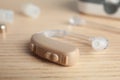 Hearing aid on wooden table, closeup.