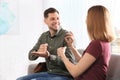 Hearing impaired friends using sign language for communication on sofa Royalty Free Stock Photo