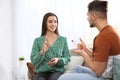 Hearing impaired friends using sign language for communication on sofa Royalty Free Stock Photo