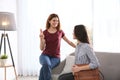 Hearing impaired friends using sign language for communication on sofa Royalty Free Stock Photo