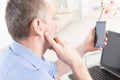 Hearing impaired man working with laptop and mobile phone Royalty Free Stock Photo