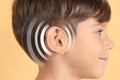 Hearing loss concept. Little boy and sound waves illustration on yellow background, closeup Royalty Free Stock Photo
