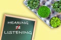 Hearing not equal listening written on chalkboard  with planting a few tree Royalty Free Stock Photo