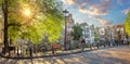 Heart of Amsterdam. Early morning in Amsterdam. Ancient houses, a bridge, traditional bicycles, canals and the sun shines through