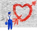 Heart and arrow painted on brick wall by man