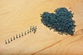 Heart and arrow symbols made of metal screws on a plywood sheet