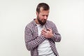 Heart attack, cardiological problems. Portrait of stressed out bearded man grabbing chest suffering acute pain cramp. white