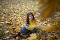 Happy girl in autumn forest with yellowing leaves