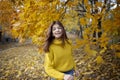 Happy girl in autumn forest with yellowing leaves