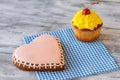 Heart biscuit and yellow cupcake. Royalty Free Stock Photo