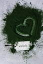 Heart on Blue-green algae Chlorella and spirulina powder with paper note text SPIRULINA. Super powder. Natural