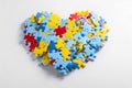 Heart from blue, light blue, red and yellow puzzles. World Autism Awareness day concept. Generative AI illustration.