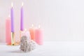 Heart and burning candles in pastel colors on white textured background. Royalty Free Stock Photo