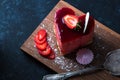 Heart Cake picture . Lovely delicious heart cake. A red colored cheesecake on a plate and a wooden table.