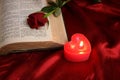 Heart candle on open Bible and red rose Royalty Free Stock Photo