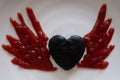 Heart chocolate cake have decorated by ketchup is drawing wings on white plate. for kid meal.