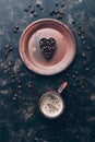 Heart of coffee beans and hot coffee drink in a vintage cup on a rustic dark background. Valentine`s Day.Top view, place for text Royalty Free Stock Photo
