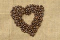 Heart coffee. Roasted coffee beans in the shape of heart on natural canvas, sackcloth. Concept of coffee love or a loved Royalty Free Stock Photo