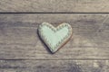 Heart cookie covered with blue icing and edible pearl beads