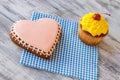 Heart cookie and yellow cupcake. Royalty Free Stock Photo