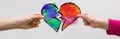 Divorce? The man holds half of the heart in blue and green and the woman the other half in red and yellow.