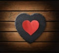 Heart cutout on heart-shaped slate plate on wooden slatted table