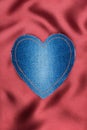 Heart of denim fabric with yellow stitching on red silk Royalty Free Stock Photo