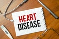 Heart disease with notepad with stethoscope on desk Royalty Free Stock Photo
