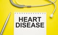 Heart disease with notepad with stethoscope on desk Royalty Free Stock Photo