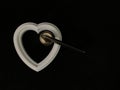 Heart with a door handle on a black background. The white heart opens with a hand. Concept: closed heart Royalty Free Stock Photo