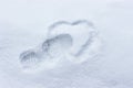 Heart drawing in the snow. Footprint and silhouette of the heart. Winter concept broken heart, unhappy love, coldness Royalty Free Stock Photo